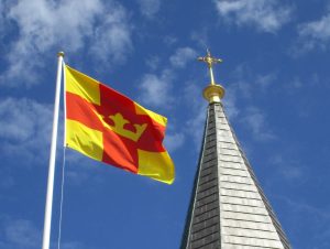 Bild av Smögens kyrktorn och Svenska kyrkans flagga